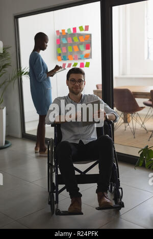 Exécutif Handicap looking at camera while using digital tablet Banque D'Images