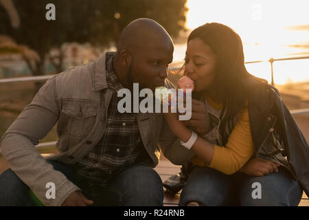 Couple having ice cream sur banc de la promenade Banque D'Images