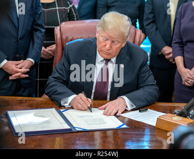 Le Président des Etats-Unis, Donald J. Trump signe la cybersécurité et la sécurité de l'infrastructure dans la Loi sur l'Agence le bureau ovale de la Maison Blanche à Washington, DC le vendredi 16 novembre, 2018. Le Président a également répondu aux questions de journalistes. Credit : Ron Sachs / Piscine d'utilisation dans le monde entier via CNP | Banque D'Images