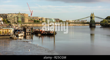 Londres, Angleterre, Royaume-Uni - 9 septembre 2018 : péniches sont amarrées à un ponton sur la Tamise, à côté du pont suspendu de Hammersmith à l'ouest de Londres. Banque D'Images