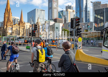 Les cyclistes attendre au feu rouge dans le centre-ville de Melbourne, Victoria, Australie Banque D'Images