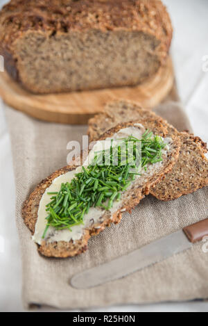 Tranche de pain de seigle avec du beurre et de la ciboulette fraîche Banque D'Images