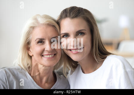 Souriante jeune femme et vieille mère looking at camera, portrait Banque D'Images