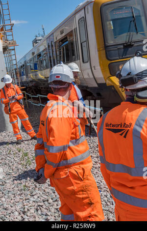 Network Rail track travailleurs dans des vêtements haute visibilité l'attente d'un train avant de continuer le travail. Banque D'Images