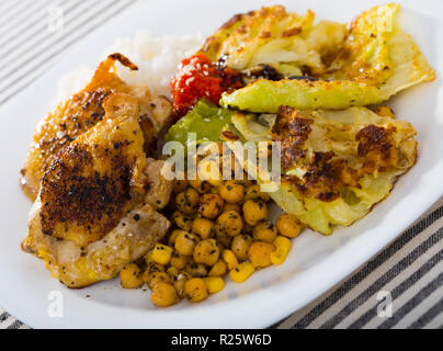 Cuisses de poulet au four avec du chou battues, le pois chiche, le riz et les sauces Banque D'Images