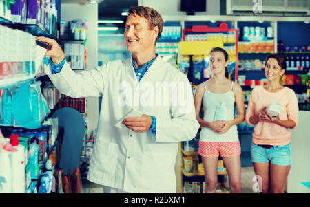 Friendly Smiling man pharmacien en uniforme et de travail dans l'industrie pharmaceutique shop Banque D'Images