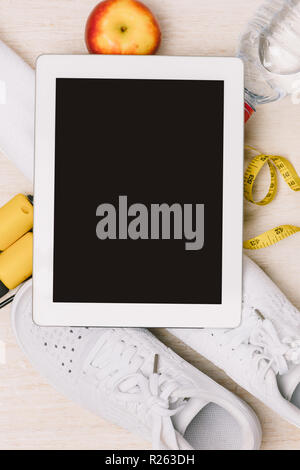 Concept de remise en forme avec l'ipad, une serviette et des chaussures de sport sur fond de bois Banque D'Images