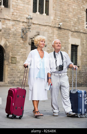 Voyages conjoints matures debout devant l'ancienne cathédrale avec la carte et l'appareil photo Banque D'Images