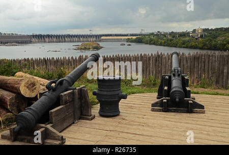 Grand vieux canons sur les peuplements de bois dans le contexte d'une palissade en bois et sont destinées à le barrage hydroélectrique à Zaporojie sur le Khortits Banque D'Images