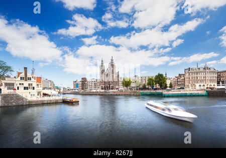 RK Nicolaaskerk église avec Hôtel et appartement le long de la rivière ou du canal ou d'un bateau de croisière pour le transport et aussi sur la route de bus et de tramway dans le centre de Banque D'Images