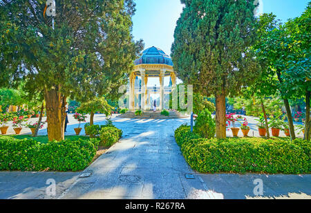 À pied l'allée ombragée de Moussala jardins avec une vue panoramique sur l'alcôve de la tombe de Hafez, Shiraz, Iran. Banque D'Images