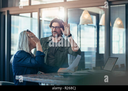 Deux collègues d'affaires se donnant un grand cinq et souriant. l'équipe commerciale se réjouit du succès. Banque D'Images