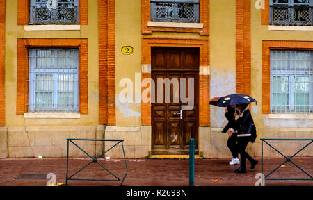 Les gens avec des parasols une marche sous la pluie dans la rue Saint-Pierre, Toulouse, France Banque D'Images