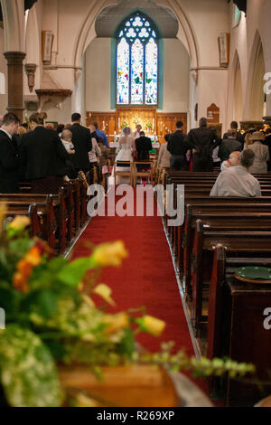 Mariée et le marié se marier à l'église autel comme congrégation watch. Vitrail en arrière-plan Banque D'Images