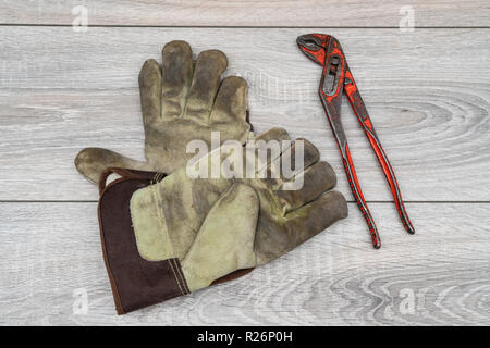 Un parrot key et une paire de gants de travail sur une table en bois Banque D'Images