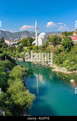 Août 2013, Mostar. Vue de la mosquée Koski Mehmed Pacha et son grand minaret blanc sur la rive de la rivière Neretva comme vu du Vieux Pont Banque D'Images