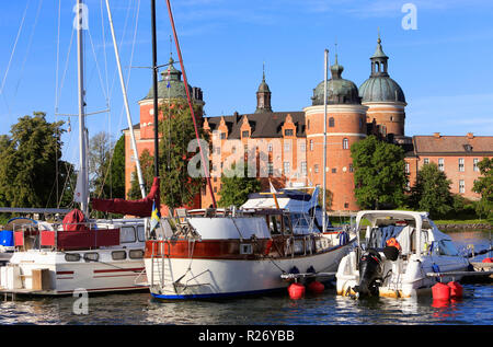 Mariefred, Suède - le 18 août 2018 : les bateaux de plaisance en face de l'ancien château Gripsholm couleur rouge construit au cours du 16ème siècle. Banque D'Images