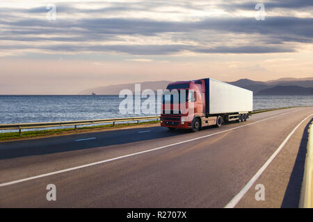 Camion rouge sur une route près de la mer Banque D'Images