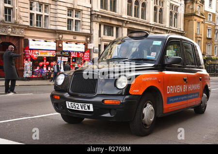 Londres - le 17 décembre 2017 : London taxi style traditionnel prend le passager. Banque D'Images