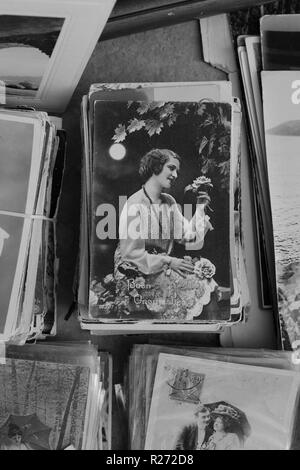 Athènes, Grèce - 14 septembre 2018 : Vintage carte postale de jeune femme avec des roses par la lune et les vieilles photographies en vente au magasin d'antiquités. Black Banque D'Images