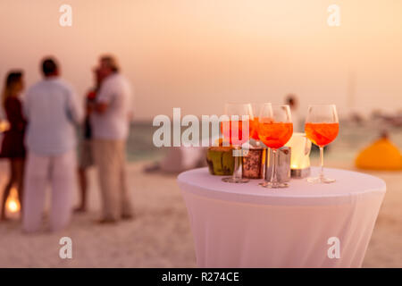 Les personnes ayant des trouble-fête de plage au coucher du soleil en été locations - image flou artistique - Notion d'Aperol vie nocturne avec des cocktails et musique, spectacles Banque D'Images