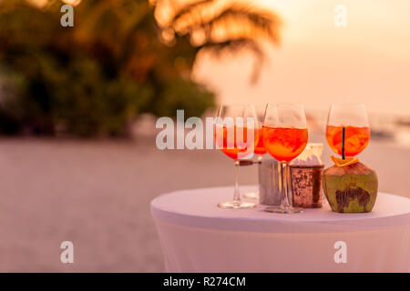 Les personnes ayant des trouble-fête de plage au coucher du soleil en été locations - image flou artistique - Notion d'Aperol vie nocturne avec des cocktails et musique, spectacles Banque D'Images