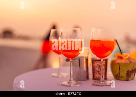 Les personnes ayant des trouble-fête de plage au coucher du soleil en été locations - image flou artistique - Notion d'Aperol vie nocturne avec des cocktails et musique, spectacles Banque D'Images