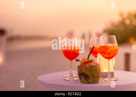 Les personnes ayant des trouble-fête de plage au coucher du soleil en été locations - image flou artistique - Notion d'Aperol vie nocturne avec des cocktails et musique, spectacles Banque D'Images