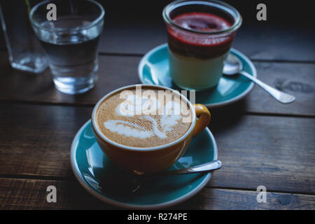 Gâteau au fromage avec du café dans un verre sur la table en bois Banque D'Images