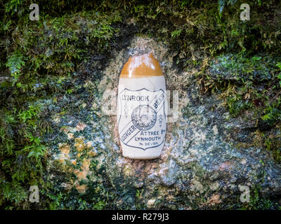 Une vieille bouteille de bière au gingembre Lynrock situé dans un mur dans la rivière West Lyn Valley à Lynmouth, Exmoor, Devon UK sur le site d'un ancien facteur de l'eau minérale Banque D'Images