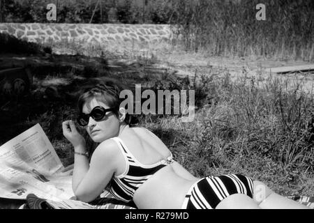 Jeune femme dans un cycliste portant des lunettes de lecture, un journal des années 1970, la Hongrie Banque D'Images