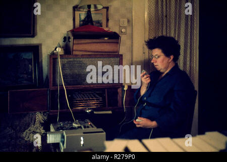 Femelle adulte tenant un microphone relié à rouleau à rouleau enregistreur relié à un projecteur de diapositives faisant une présentation audiovisuelle des années 70, la Hongrie Banque D'Images