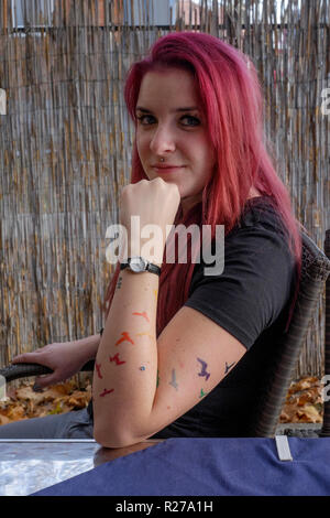 Portrait d'une jeune femme avec des cheveux teints en rouge et les chauves-souris tatoué sur son bras lenti Hongrie Zala County Banque D'Images