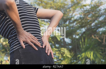 Une femme souffrant de Mal de dos, la moelle épinière et les muscles cause problème à l'extérieur. Banque D'Images