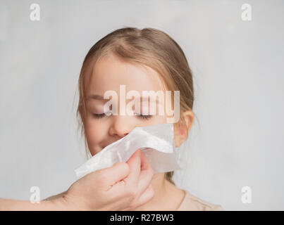 L'écoulement nasal chez les enfants. Maman de son bébé lingettes le nez avec un mouchoir. Banque D'Images