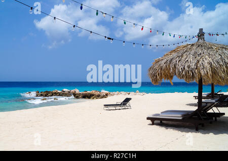 Tiki Hut sur la plage de sable blanc, eau bleue et lumières colorées. Paradise sur Curaçao. Banque D'Images