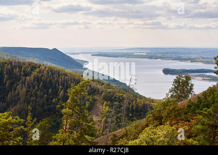 River contre le ciel nuageux avec des nuages et de la forêt. Banque D'Images