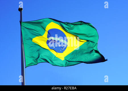 Drapeau du Brésil dans le vent en face d'un ciel bleu, ensoleillé et isolé. Banque D'Images