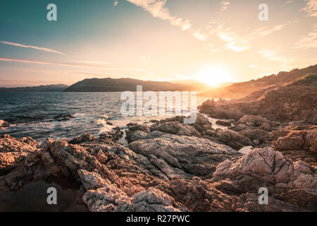 Lever du soleil sur la côte rocheuse à Lozari en Corse de Balagne Banque D'Images