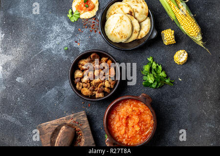 Cuisine traditionnelle colombienne. Chicharron, maïs arepas avec sauce à l'oignon et de tomate. Banque D'Images