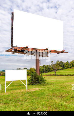 Shot vertical à légèrement incliné à droite d'un blank billboard géant avec un petit signe vierge ci-dessous les deux avec l'exemplaire de l'espace. Banque D'Images