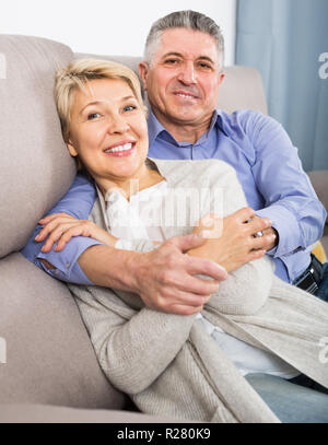 Couple marié de maturité satisfait maison confortable sont chaleureusement réconciliée après querelle Banque D'Images