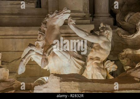 Triton mythologique dompte un hippocampe, dans la magnifique fontaine de Trévi à Rome de nuit (18e siècle) Banque D'Images