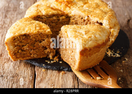 Tourtiere tranchées graphique avec la viande, de la purée de pommes et d'épices sur la table horizontale. Banque D'Images