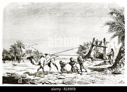 Vieille illustration levage de l'eau du puits a Metlili ., l'Algérie. Par Couverchel, publ. sur le Tour du Monde, Paris, 1863 Banque D'Images