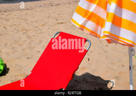 Impressions d'été sur la plage, soleil rouge dans la plage de sable fin avec un parasol comme matériel de plage Banque D'Images