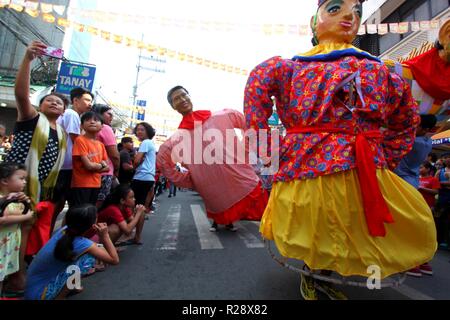 En tourisme photo pendant l'Higantes selfies (Géant) marches effigie dans la rue Ville de Angono province de Rizal le 18 novembre 2018. Higantes (Géant) Festival est célébré en novembre dans la ville de Angono, province de Rizal aux Philippines en l'honneur de San Clemente, le patron des pêcheurs. Le festival propose un défilé de centaines de higantes, papier mâché géants. Higantes (marionnettes géantes) sont rendus comme homme ou femme dans divers costumes ; leur visage donne un look, commandant la main sur la taille. (Photo par Gregorio B. Dantes Jr./Pacific Press) Banque D'Images