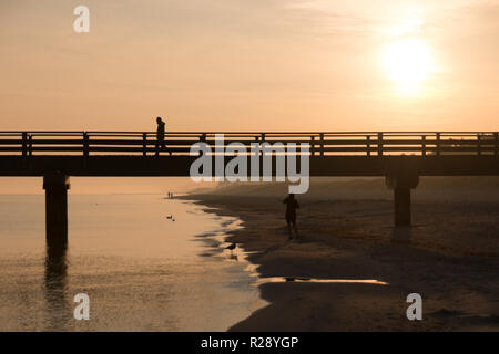 Prerow, Allemagne - 10 octobre 2018 : Le jogging alors que le soleil se lève le long de la mer Baltique, l'Allemagne. Banque D'Images