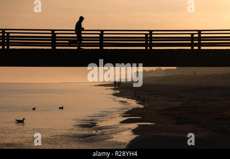 Prerow, Allemagne - 10 octobre 2018 : Le jogging alors que le soleil se lève le long de la mer Baltique, l'Allemagne. Banque D'Images