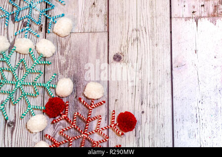 Pom Pom tissu ficelle flocons en blanc, rouge, couleurs et des sarcelles. Fond en bois, utile pour les projets de vacances de Noël rustique Banque D'Images